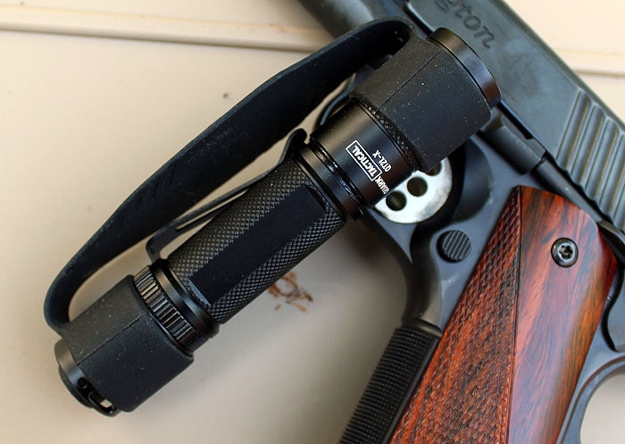 QT2L-X flashlight sitting on top of handgun