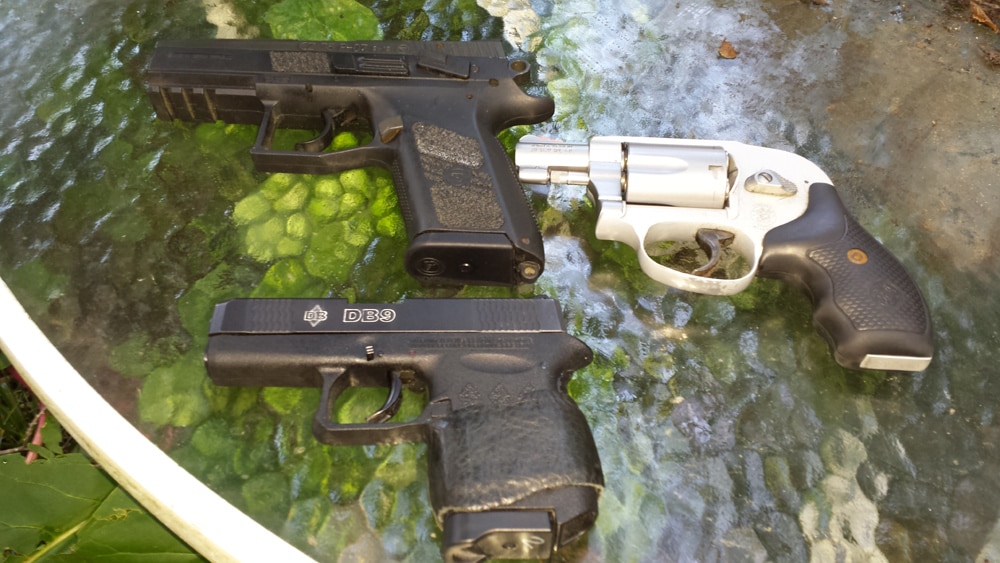 3 pocket pistols sitting on a glass table