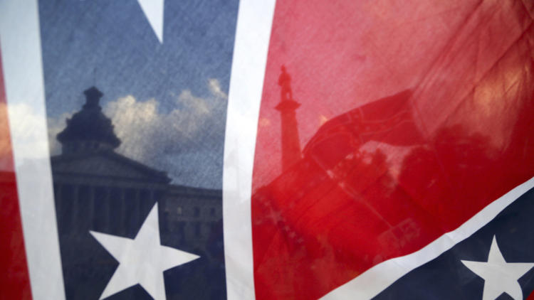 The South Carolina Statehouse is seen through a Confederate flag in Columbia.  (Gerry Melendez / Associated Press)