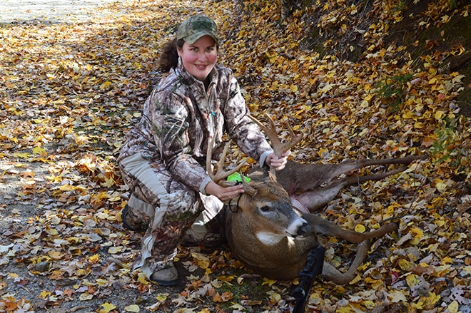 female hunter posing with trophy deer