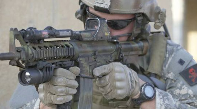 A soldier pointing a rifle equipped with an EOTech scope. 
