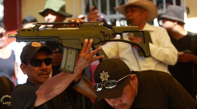 A Heckler-Koch HK G36C assault rifle, which was seized from a house during an operation, is held up by a member of the Community Police of the FUSDEG (United Front for the Security and Development of the State of Guerrero) during a presentation in the village of Petaquillas, on the outskirts of Chilpancingo, in the Mexican state of Guerrero, February 1, 2015. (Photo by Jorge Dan Lopez/Reuters) 