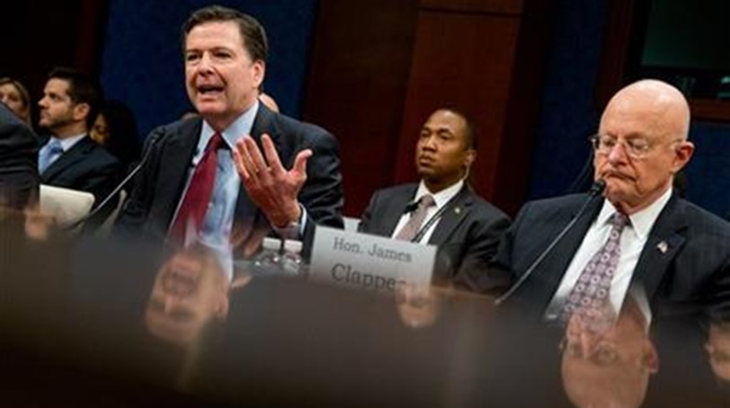 FBI Director James Comey, left, accompanied by Director of National Intelligence James Clapper, right, speaks at a House Intelligence Committee hearing on world wide threats on Capitol Hill in Washington, Thursday, Feb. 25, 2016. Comey says Apple had been "very cooperative" in the dispute and that there have been "plenty" of negotiations between the two sides. (AP Photo/Andrew Harnik)