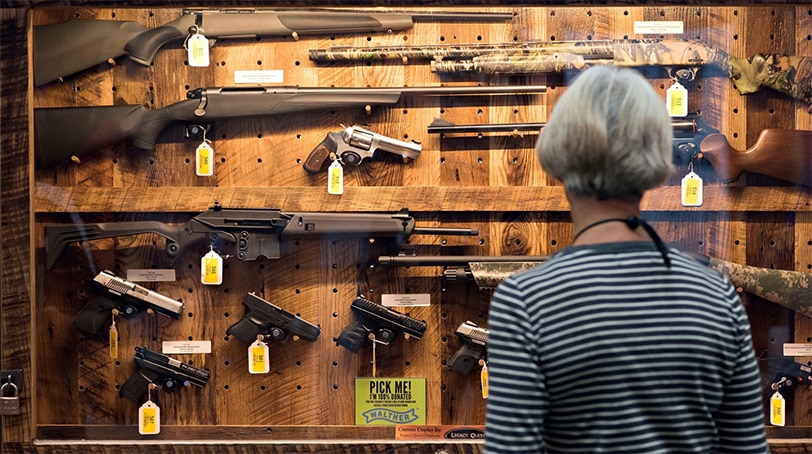 A woman peruses a gun case. (Photo: Bloomberg)