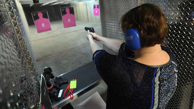 female shooting pink targets at indoor shooting range