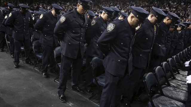 Newly inducted New York Police officers observe a solemn moment at a graduation ceremony at Madison Square Garden on Dec. 29, 2015 (Photo: Reuters)