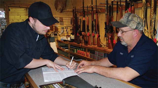 A man fills out a firearms background check form (Photo: FixNICS.com)