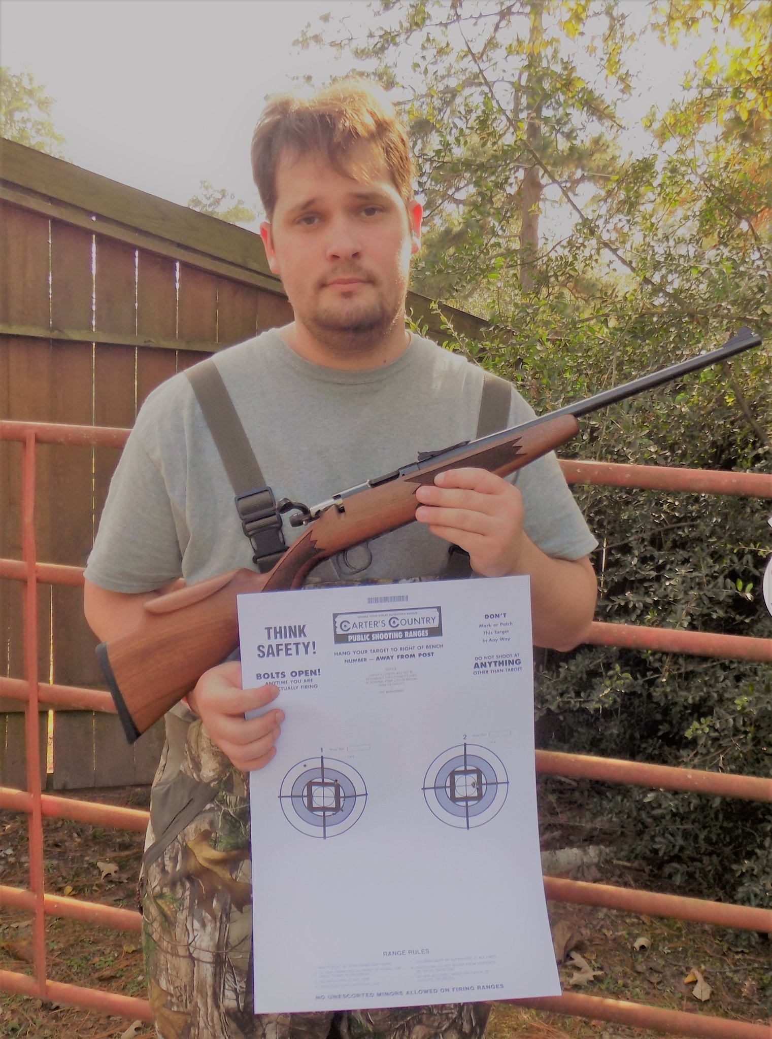 The author showing off some 25 yard groups with the Keystone rifle. Note the one hole group using Federal HV Match. The left is using Remington Golden ammo.