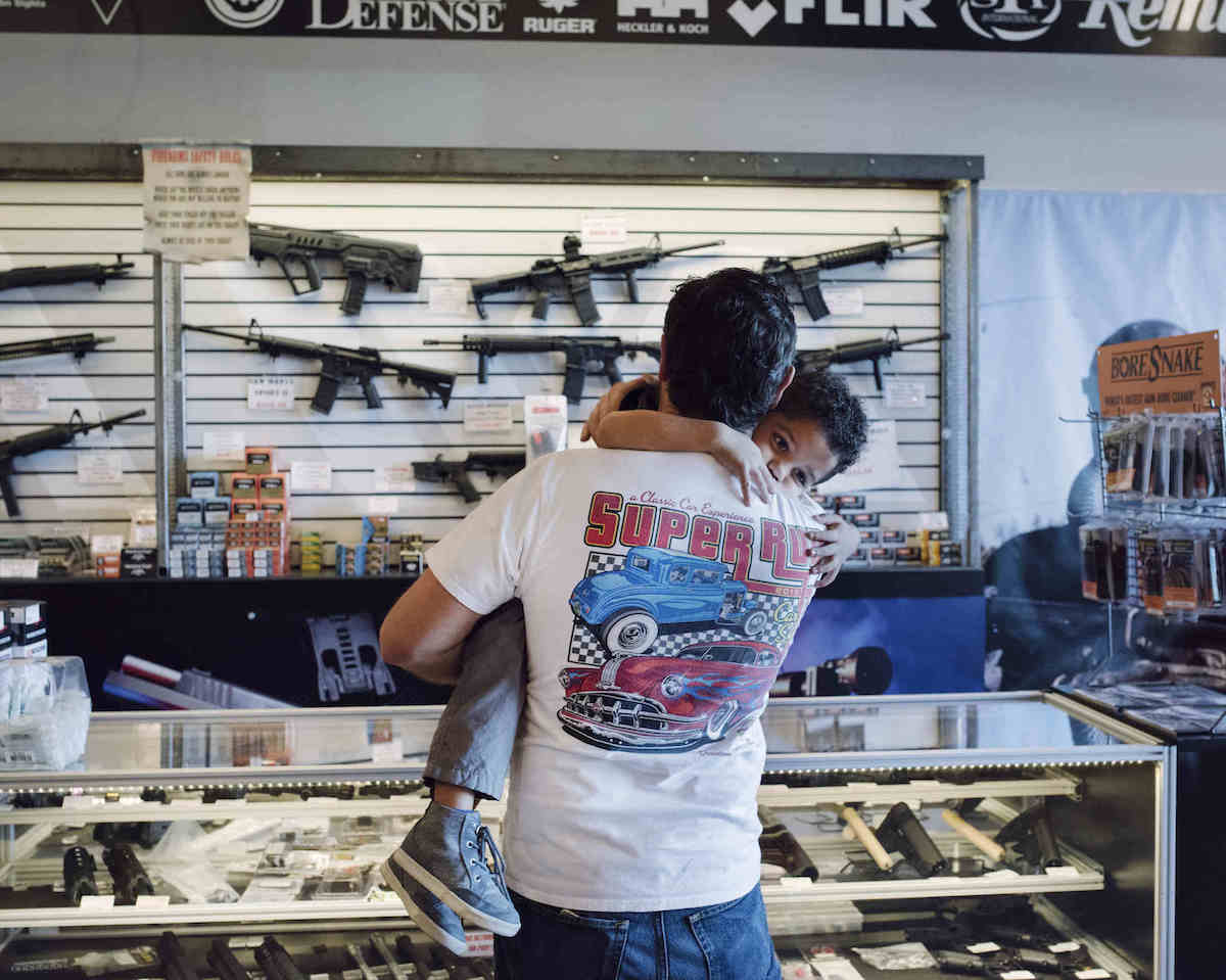 A father holds his son while checking out guns on display at Westside Armory, Las Vegas, NV (Photo: John Francis Peters)