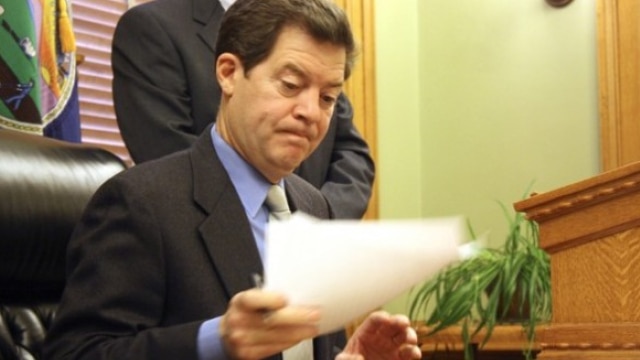 Gov. Sam Brownback (R) of Kansas has seen the state’s controversial gun rights laws defended against a lawsuit by the Brady Center but the state declined to defend two men charged in federal court with making and buying unregistered suppressors. (Photo: John Milburn/AP)