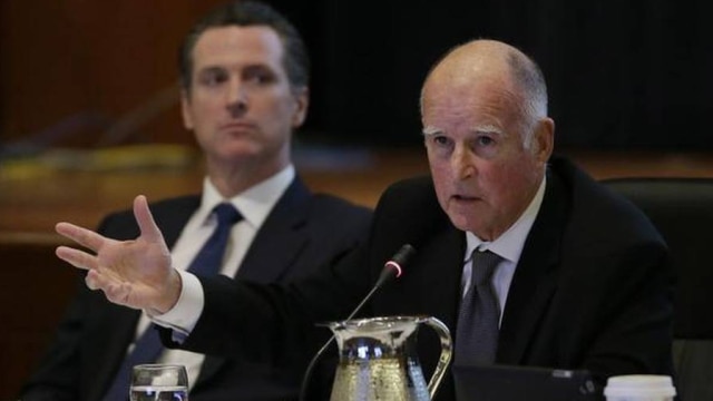 Gov. Jerry Brown, right, signed a host of new gun control bills into law only to have Lt. Gov. Gavin Newsom, left, usher through his own set of proposals via voter referendum this month. (Photo: Eric Risberg/ The Associated Press)