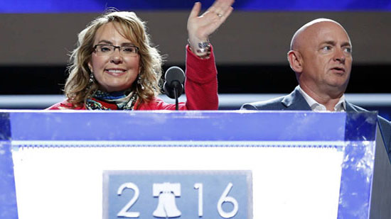Former Rep. Gabby Giffords, D-Ariz, waves from the podium as her husband Astronaut Mark Kelly (ret.) looks on during a sound check before the start of the first day session of the Democratic National Convention in Philadelphia, Monday, July 25, 2016 (AP Photo/Carolyn Kaster)