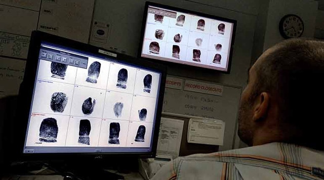 The FBI building in Clarksburg, West Virginia, houses NICS. Here an employee does some fingerprint comparisons. (Photo: WaPo)