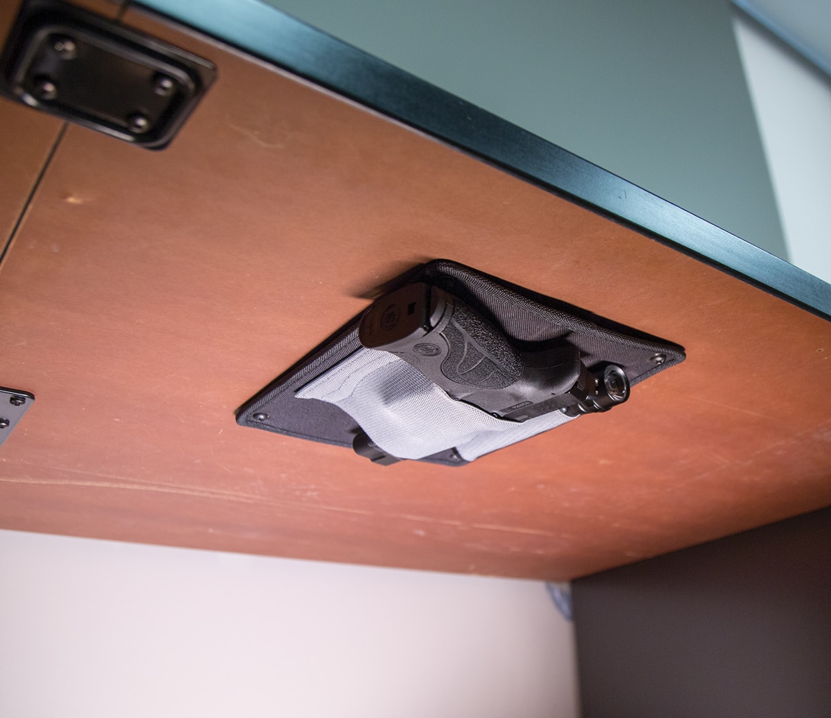 The Under Desk holster offers concealed storage of a firearm and two accessories. (Photo: Lockdown Vault Accessories)