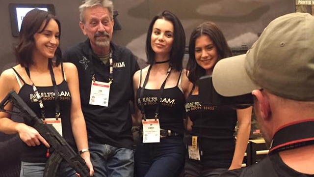Jim Fuller, owner of Rifle Dynamics, posing with booth babes at SHOT Show 2017. (Photo: Daniel Terrill/Guns.com)