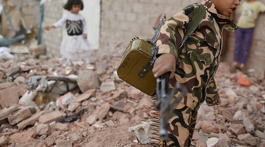 Armed boy walks through rubble in war-torn Yemen (Photo: Reuters)
