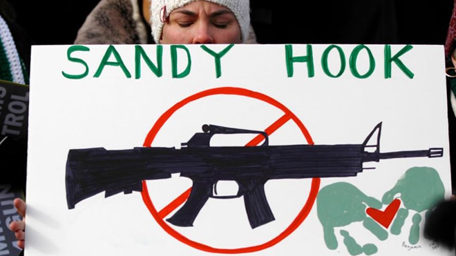 Americans hold signs memorializing Sandy Hook Elementary School, where 26 children and educators were killed in a mass shooting on December 14, 2012, as they participate in the March on Washington for Gun Control in Washington, D.C., on January 26, 2013. (Photo: Jonathan Ernst/Reuters)