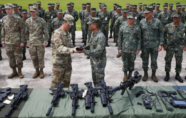 Philippine Marine Maj.Gen. Emmanuel Salamat, receives a new M4 rifle with attached M203 grenade launcher from U.S. Army Col. Ernest Lee during turnover of weapons and other equipment on June 5. (Photo: Bullit Marquez/AP)