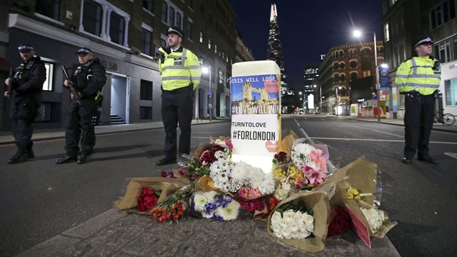 Police officers on duty stand next to floral tributes on Southwark Street in London, Sunday, June 4, 2017, near the scene of Saturday's attack. A series of attacks described as terrorism killed several people and injured dozens on Saturday. (Yui Mok/PA via AP) - See more at: https://880thebiz.com/news/world/london-police-arrest-more-suspects-in-bridge-attack#sthash.hUNABFuS.dpuf