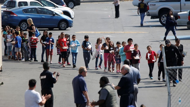 Students who were evacuated after a shooting at North Park Elementary School walk past well-wishers to be reunited with their waiting parents at a high school in San Bernardino, California, U.S. April 10, 2017. (Photo: Mario Anzuoni/ Reuters)