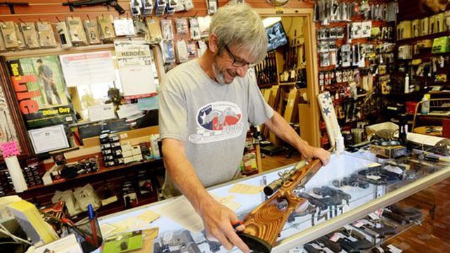 Gene Mock, co-owner of Ron's Guns, helps a customer in Bossier City, Louisiana. (Photo: Henrietta Wildsmith/The Times)