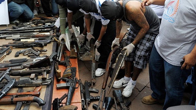 Masked gang members hand over weapons during a symbolic act for peace at Gerardo Barrios Square in San Salvador, El Salvador, on July 12, 2012. (Photo:Jose Cabezas/AFP/Getty Images)
