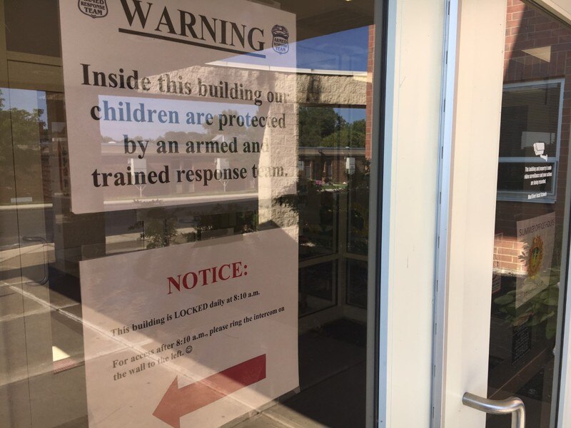 Signs warning intruders of armed staff are posted at entrances to each Mad River district school. (Photo: Nate Davis/Dayton Daily News)