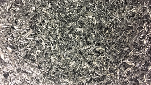 Even the trash is a work of art. A vat of silvery offal from the laser cutting process makes its own mesmerizing pattern. (Photo: Eve Flanigan)