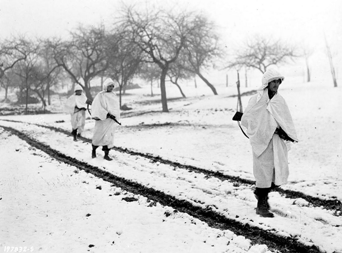 Three M1 Garand-armed members of an American patrol, Sgt. James Storey, of Newman, Ga., Pvt. Frank A. Fox, of Wilmington, Del., and Cpl. Dennis Lavanoha, of Harrisville, N.Y., cross a snow-covered Luxembourg field on a scouting mission in Lellig, Luxembourg, Dec. 30, 1944. White bedsheets camouflage them in the snow. (Photo: U.S. Army)