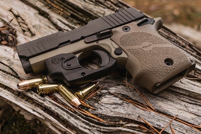 sig sauer p938 on rustic wood outdoors next to bullets