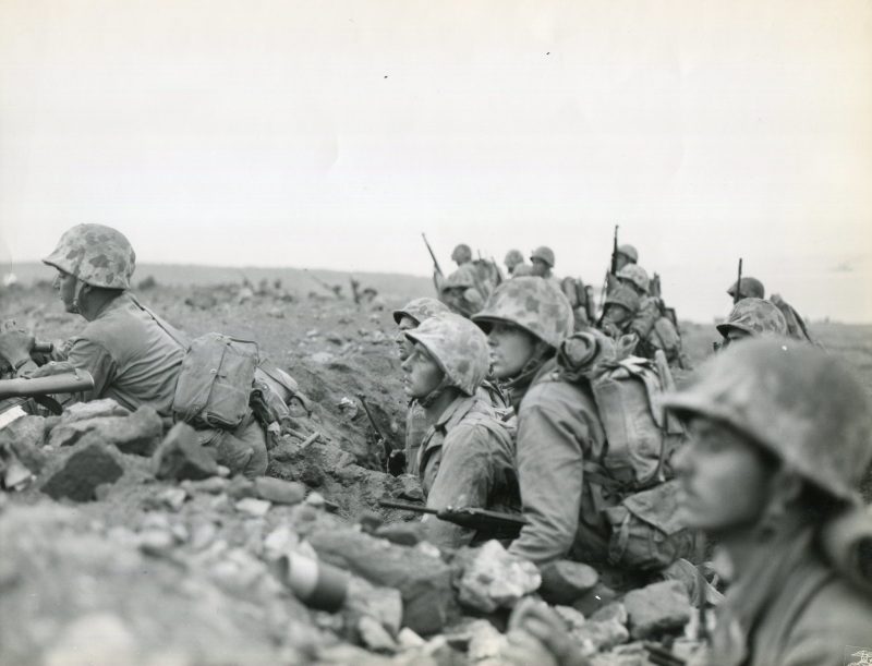 “FORMED---- Organized and formed for the assault, Marines of one of the Regiments of the Fourth Marine Division under Major General Clifton B. Cates, USMC, are ready to attack the enemy-held Motoyama Airfield Number One, on Iwo Jima, 500 yards inland from the beach.” Note the Marines in the foreground with M1 Carbines and the unmistakable profile of M1 Garands in the distance.