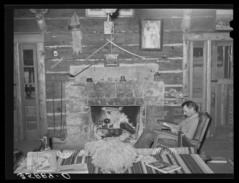 "Proprietor of the Navajo Lodge before the fireplace. Datil, New Mexico." Note the crossed cavalry sabers on the wall and what looks like a S&W Lemon Squeezer top-break revolver.