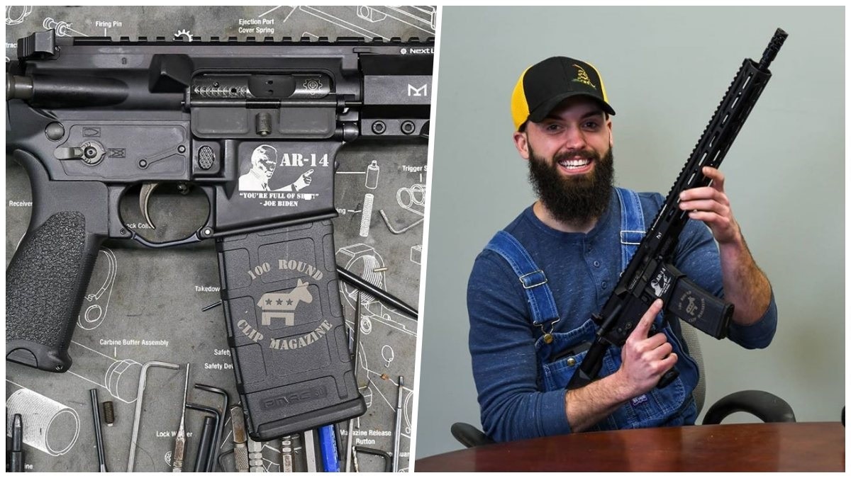 A smiling bearded man holds a new AR-14 rifle with Joe Biden's likeness on it
