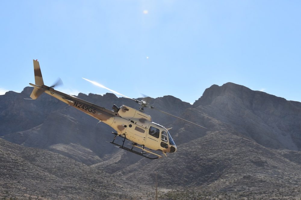 An Airbus A-Star A350 helicopter crossing a mountain