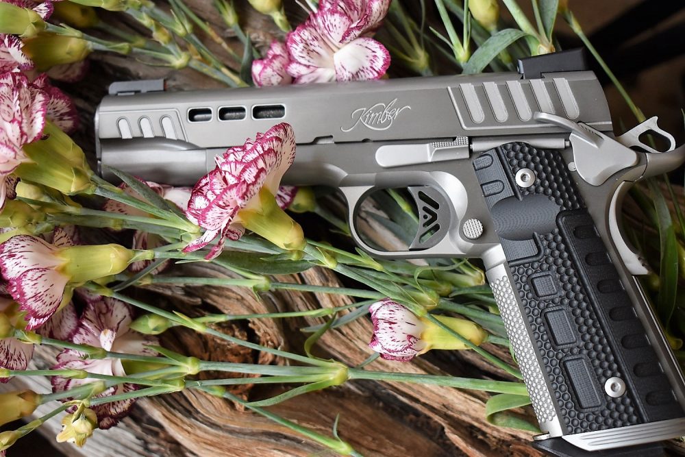 kimber rapide M1911 on a wooden block with flowers