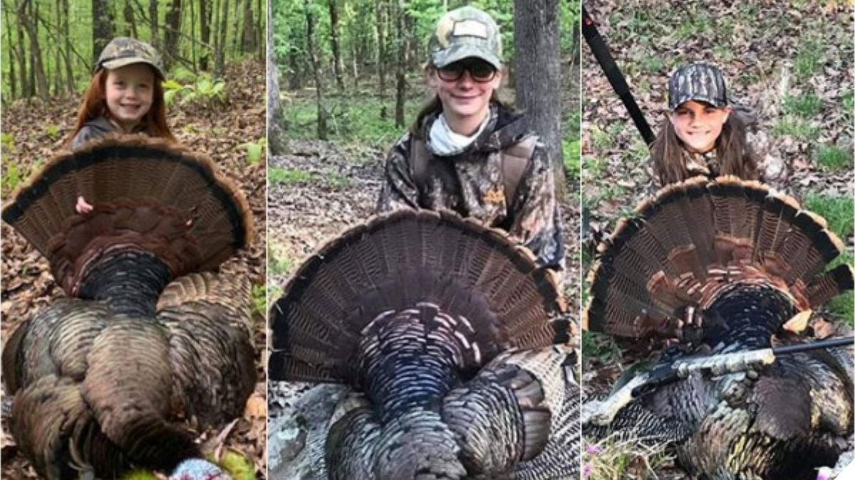 Three smiling young hunters in camouflage stand by turkeys they harvested.