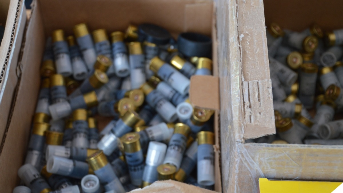 A box of shotgun shells open at the top on a shooting range