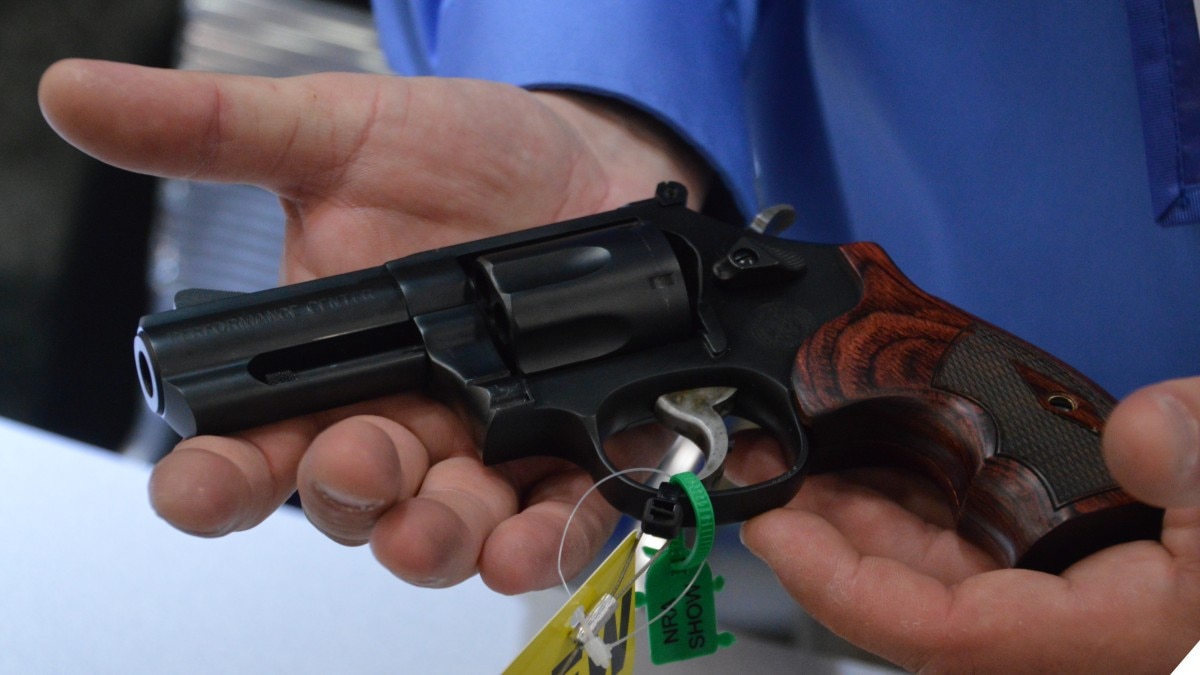 A man holds a Smith & Wesson revolver