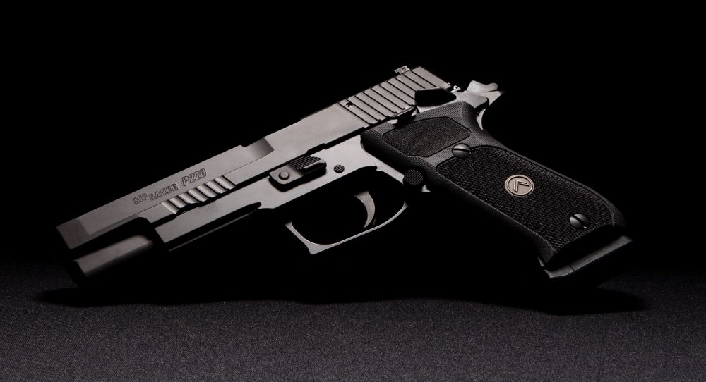 Sig Sauer P220 10mm SAO pistol on a grey background