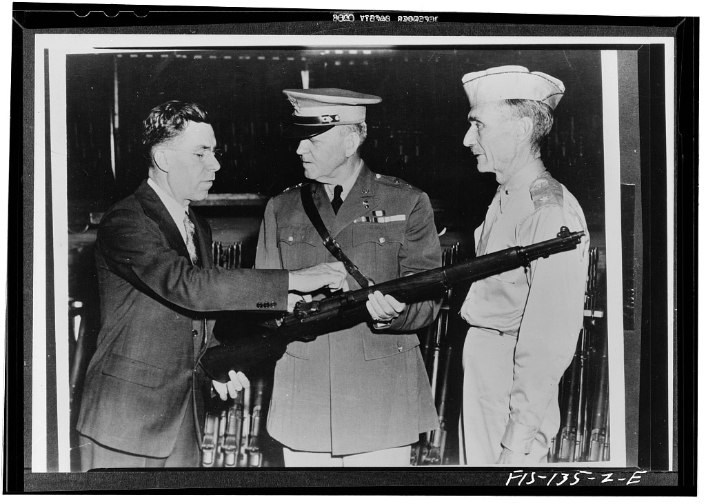 Springfield, Massachusetts. John C. Garand, inventor of the Garand rifle, pointing out some of the features of the rifle to Major General Charles M. Wesson