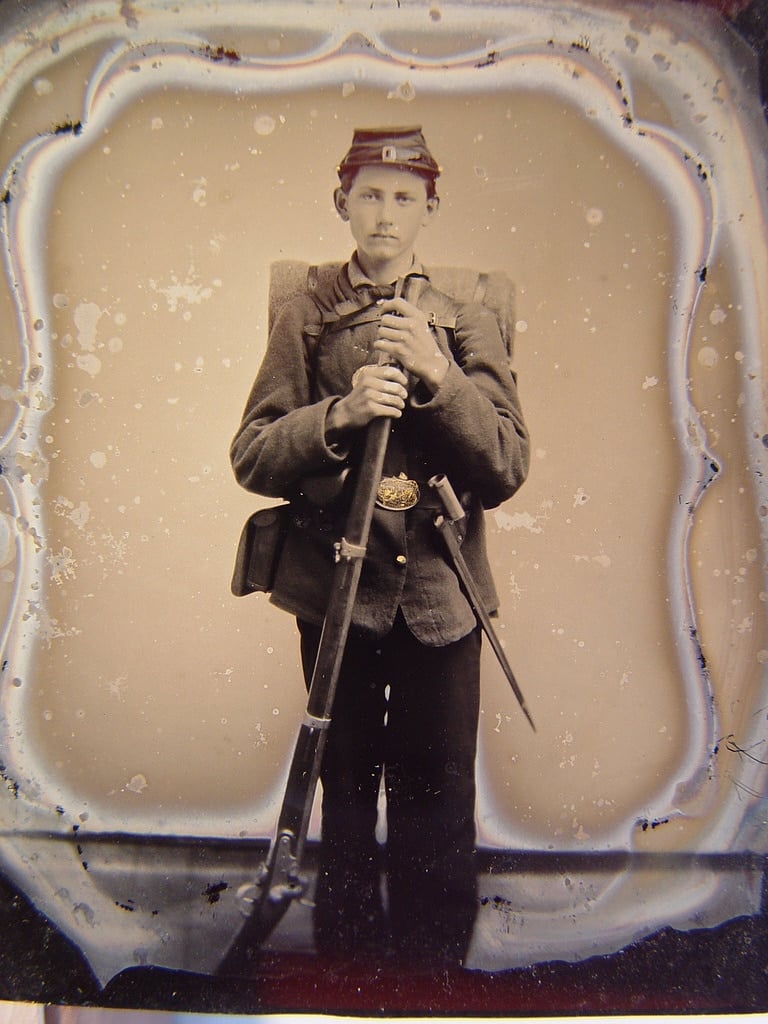 Unidentified young soldier in Union uniform with musket, bayonet, and knapsack